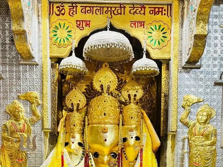 Maa Baglamukhi in the sanctum of Maa Baglamukhi Temple, Nalkheda, beneath a Hindi inscription saluting her